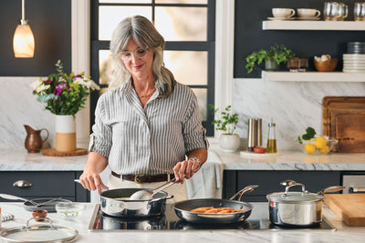 Woman cooking at home using SteelShield stainless steel nonstick cookware