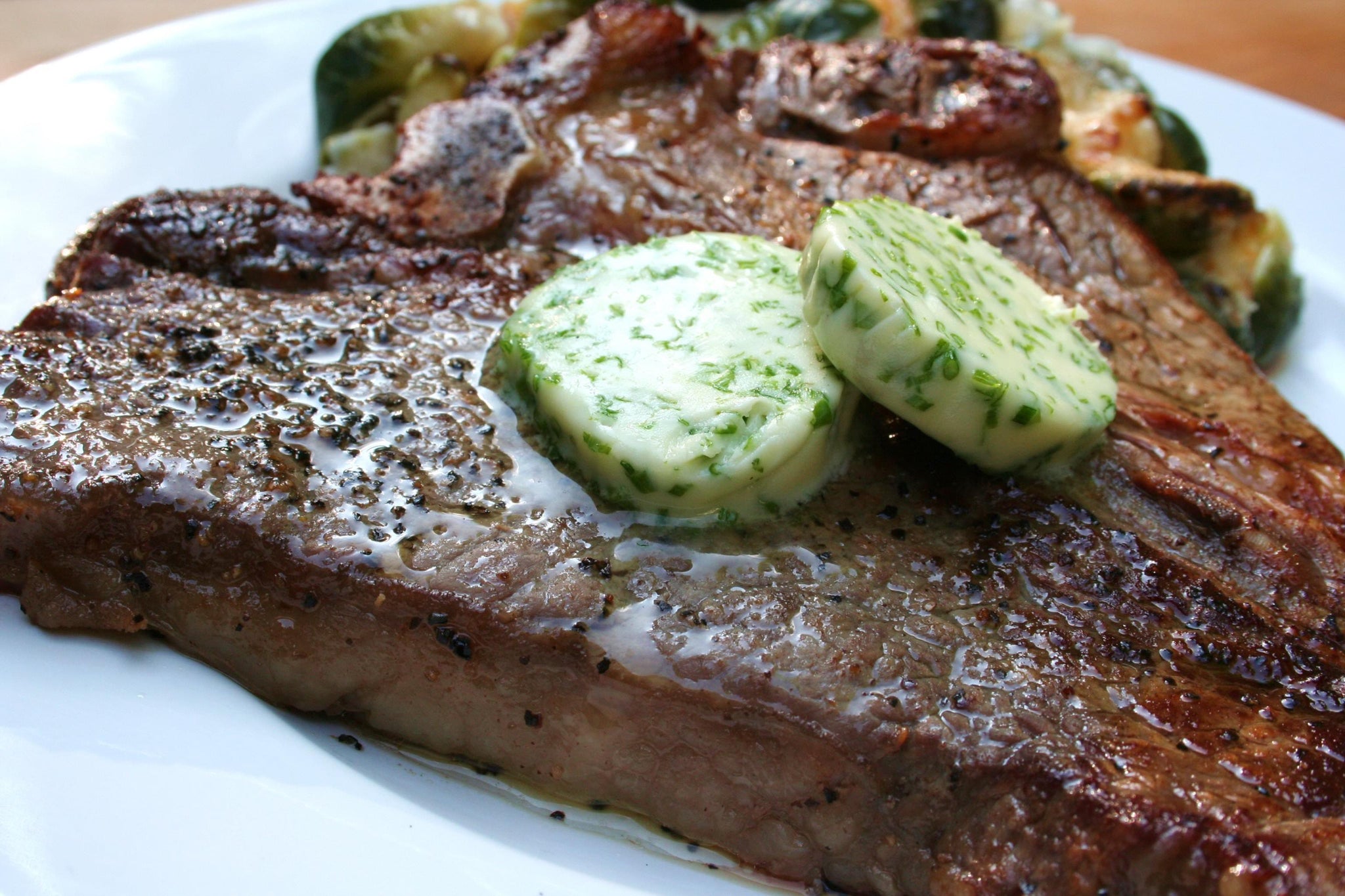 Pepper Rubbed Porterhouse Steaks with Chive Butter