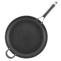 Black frying pan with a long handle and an additional loop handle.