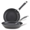 The 2-Piece Nonstick Frying Pan Set includes two black, hard-anodized frying pans with metal handles stacked on top of each other. These dishwasher-safe pans are perfect for any kitchen, offering durability and ease of use without sacrificing quality or style.