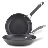 The 2-Piece Nonstick Frying Pan Set includes two black, hard-anodized frying pans with metal handles stacked on top of each other. These dishwasher-safe pans are perfect for any kitchen, offering durability and ease of use without sacrificing quality or style.