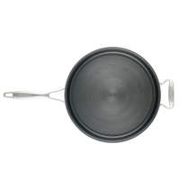 Nonstick frying pan with a circular groove pattern and a metal handle.