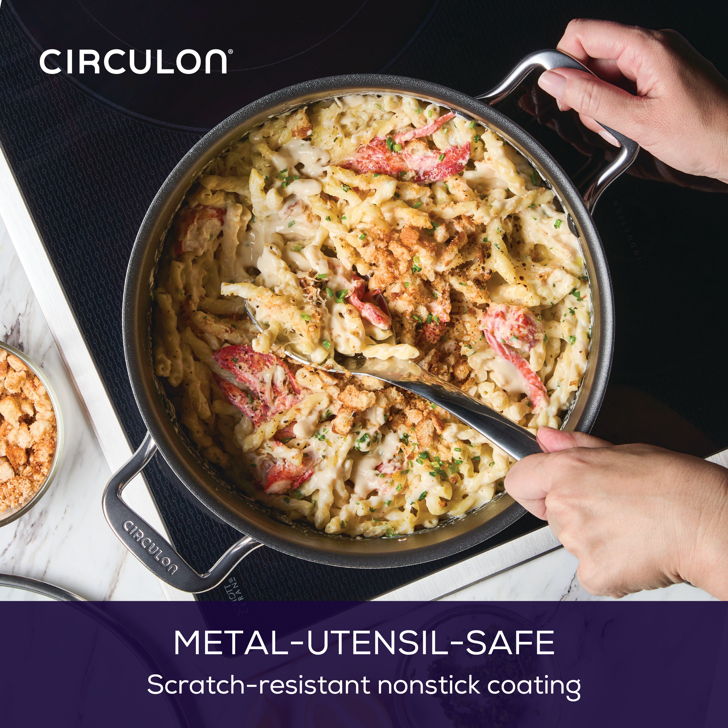 Person stirring pasta with metal spoon in a nonstick pan on a stovetop.