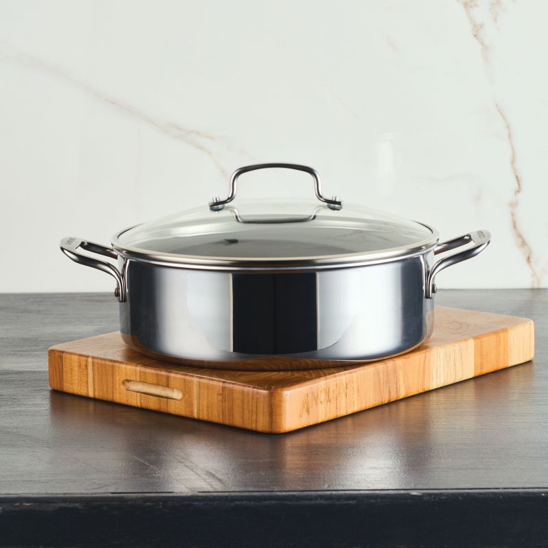 C1 Series ScratchDefense Nonstick 7-Qt Braiser with lid on a cutting board.