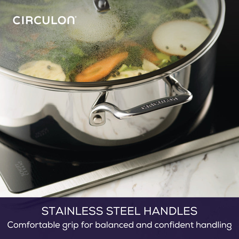 A C1 Series 7-Quart Braiser with Lid simmers veggies on an induction stove.