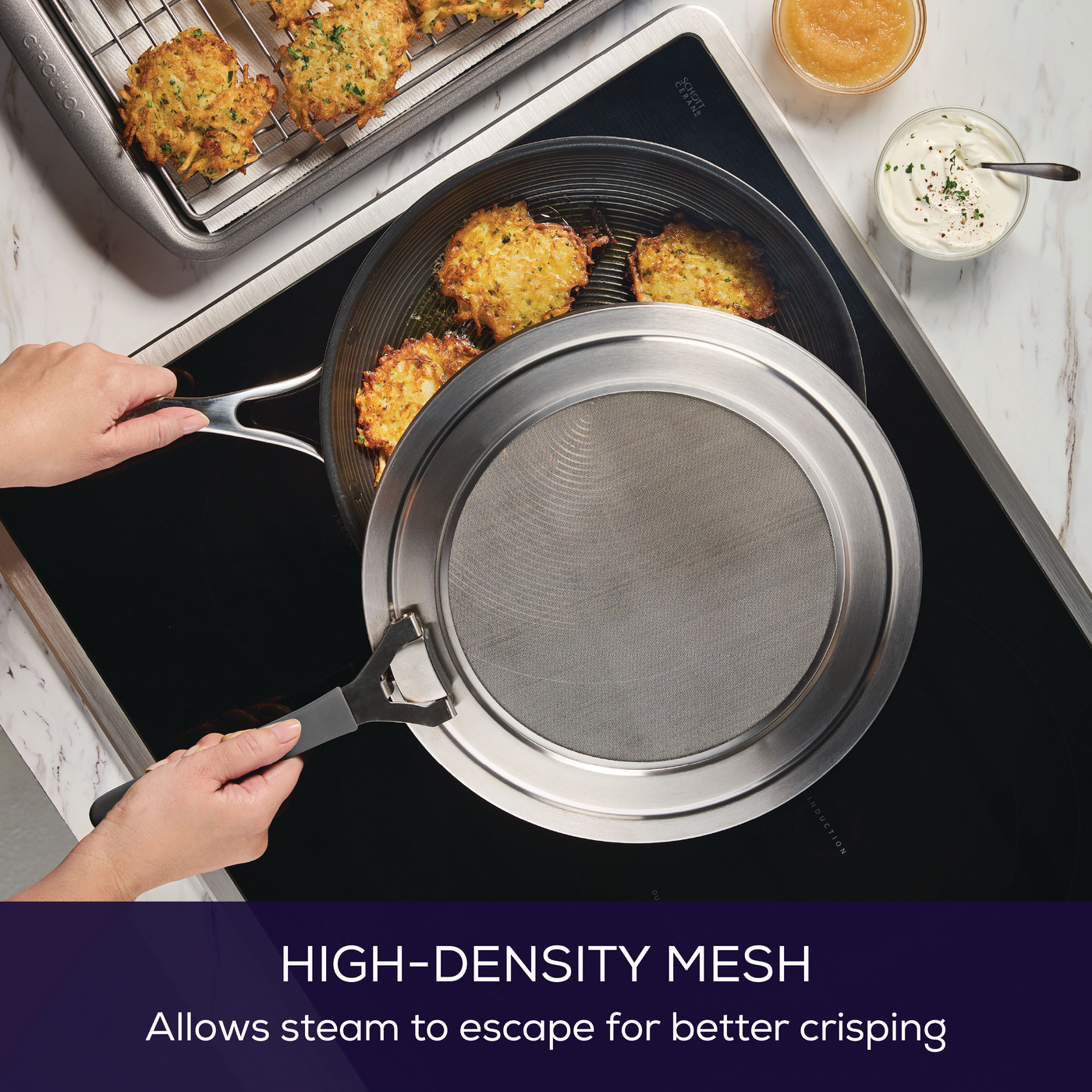 Person holding a Universal Stainless Steel Splatter Guard over food on a stovetop.