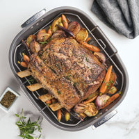 Roast beef with veggies in a Nonstick 18"x15" Oval Roaster with Rack on table.
