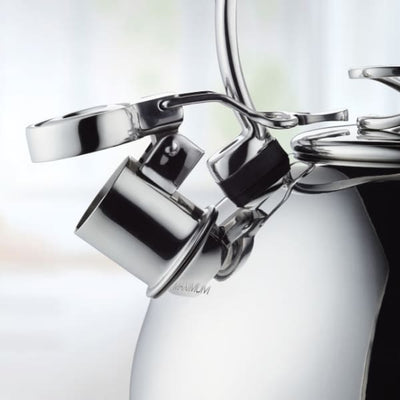 Close-up of a metallic teapot with an integrated cup design.