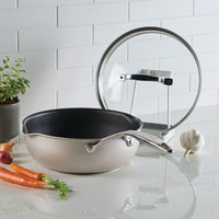 Infinity Pan with ScratchDefense™ and glass lid on counter amid vegetables.