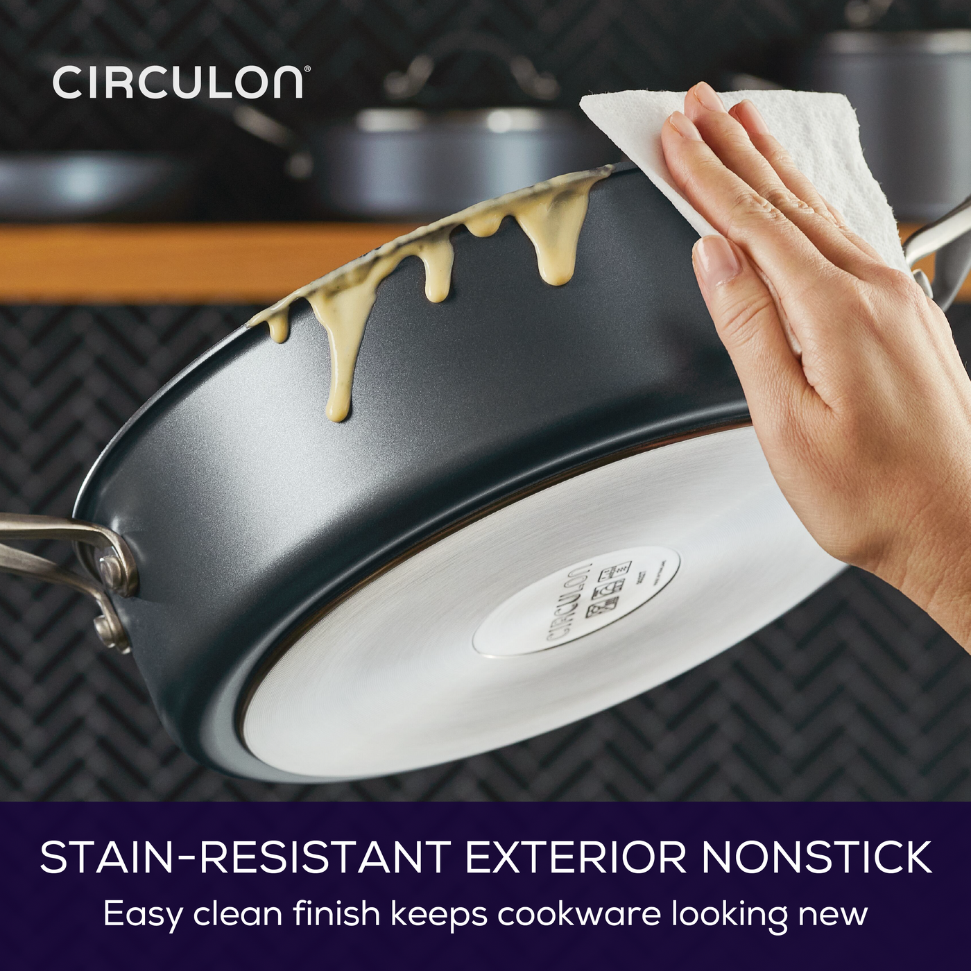 Cleaning a nonstick pan with batter on its edge using a cloth.