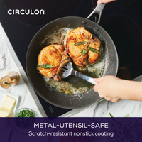 Chicken and herbs frying in a nonstick pan on an induction cooktop.