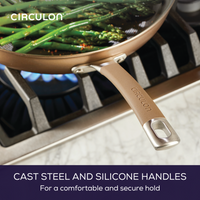 Frying pan with asparagus on a stove; cast steel and silicone handle.