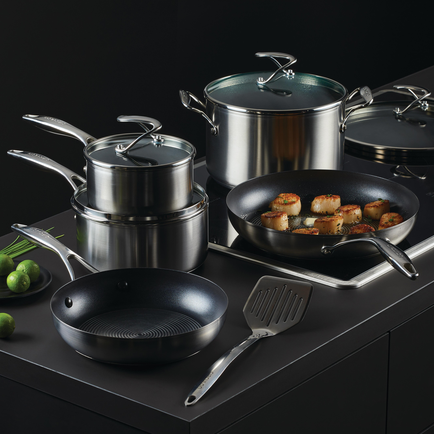 A set of stainless steel pots and pans on a kitchen counter.