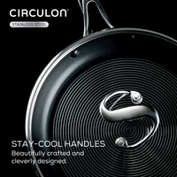 Frying pan with spiral design and a metal handle on a black background.