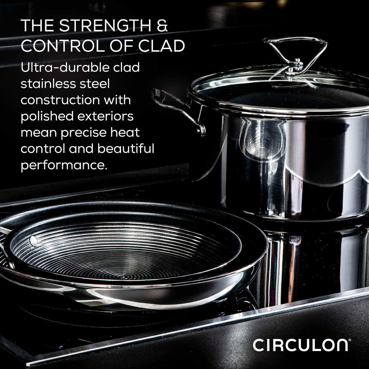 Stainless steel pots and pans on a sleek black surface.