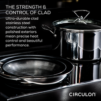 Stainless steel pots and pans on a sleek black surface.