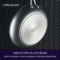 Stainless steel pan with branded induction plate base on patterned background.