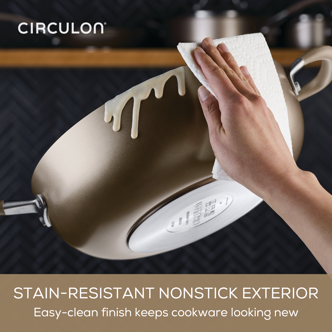 Hand wiping spilled batter off a 10-Piece ScratchDefense Nonstick pot.