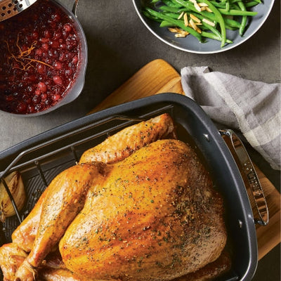 Roasted turkey with green beans and cranberry sauce on a table.