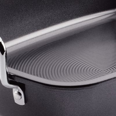Close-up of a non-stick grill pan with a ridged surface and metal handle.