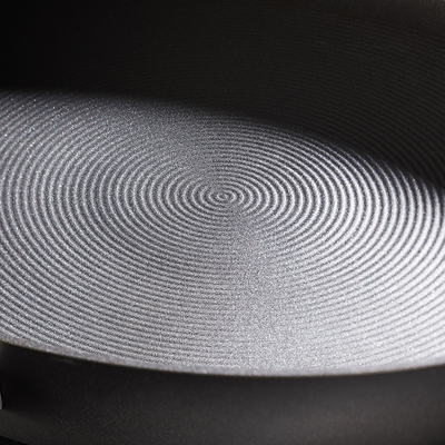 Circular pattern on a textured metallic surface viewed at a close angle.