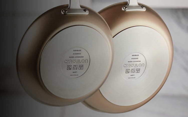 Two golden pans with nonstick coating placed vertically