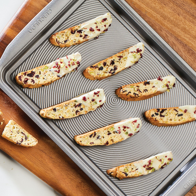 Biscotti with white chocolate and berries on a baking sheet.