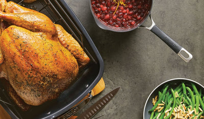 Roasted turkey, cranberry sauce, and green beans on a countertop.
