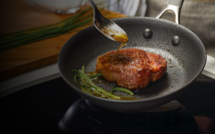 The process of frying a large piece of meat in a pan.