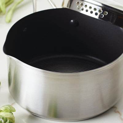 Stainless steel saucepan with spout and dark interior.