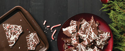 Chocolate bark with crushed candy canes on a tray and plate.