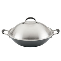 Stainless steel wok with a lid and side handles.