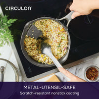 Person stirring couscous in a pan on an induction stove.