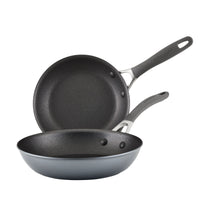 Two non-stick frying pans with gray handles stacked together.