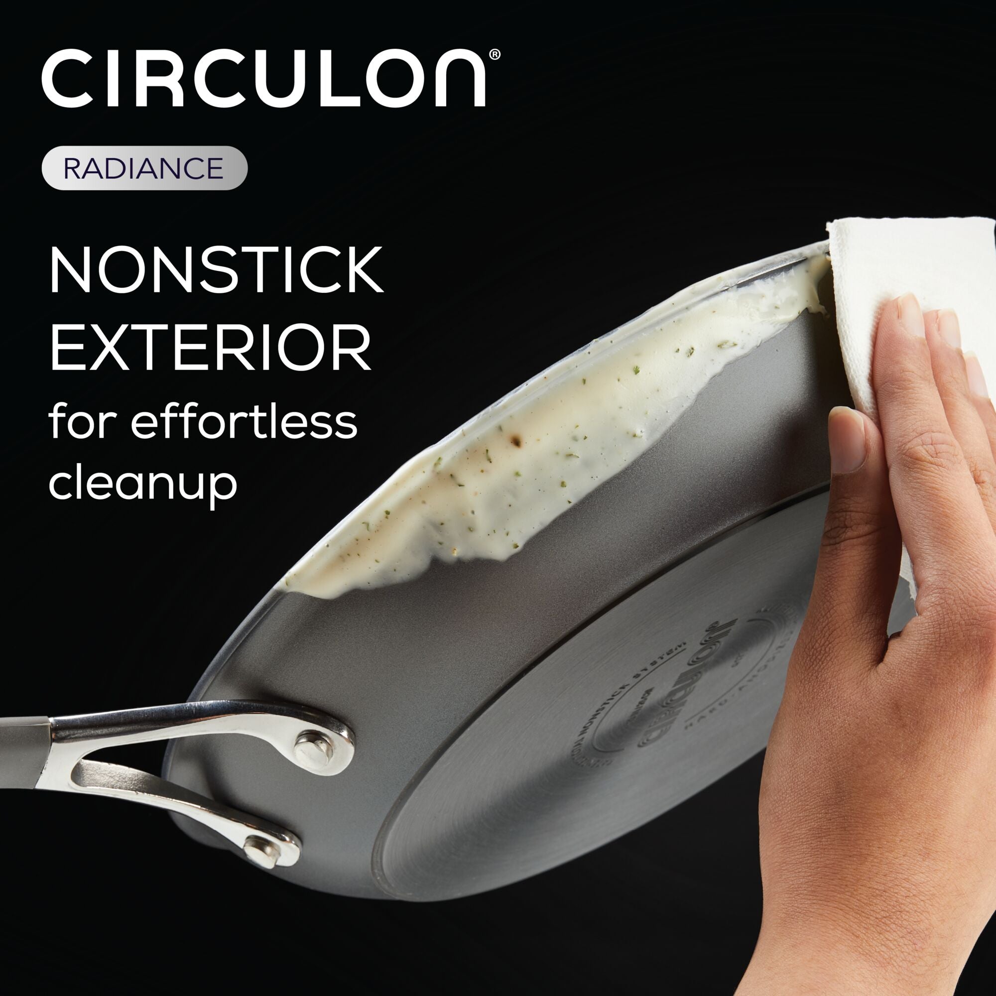 Hand wiping a nonstick pan with a cloth.