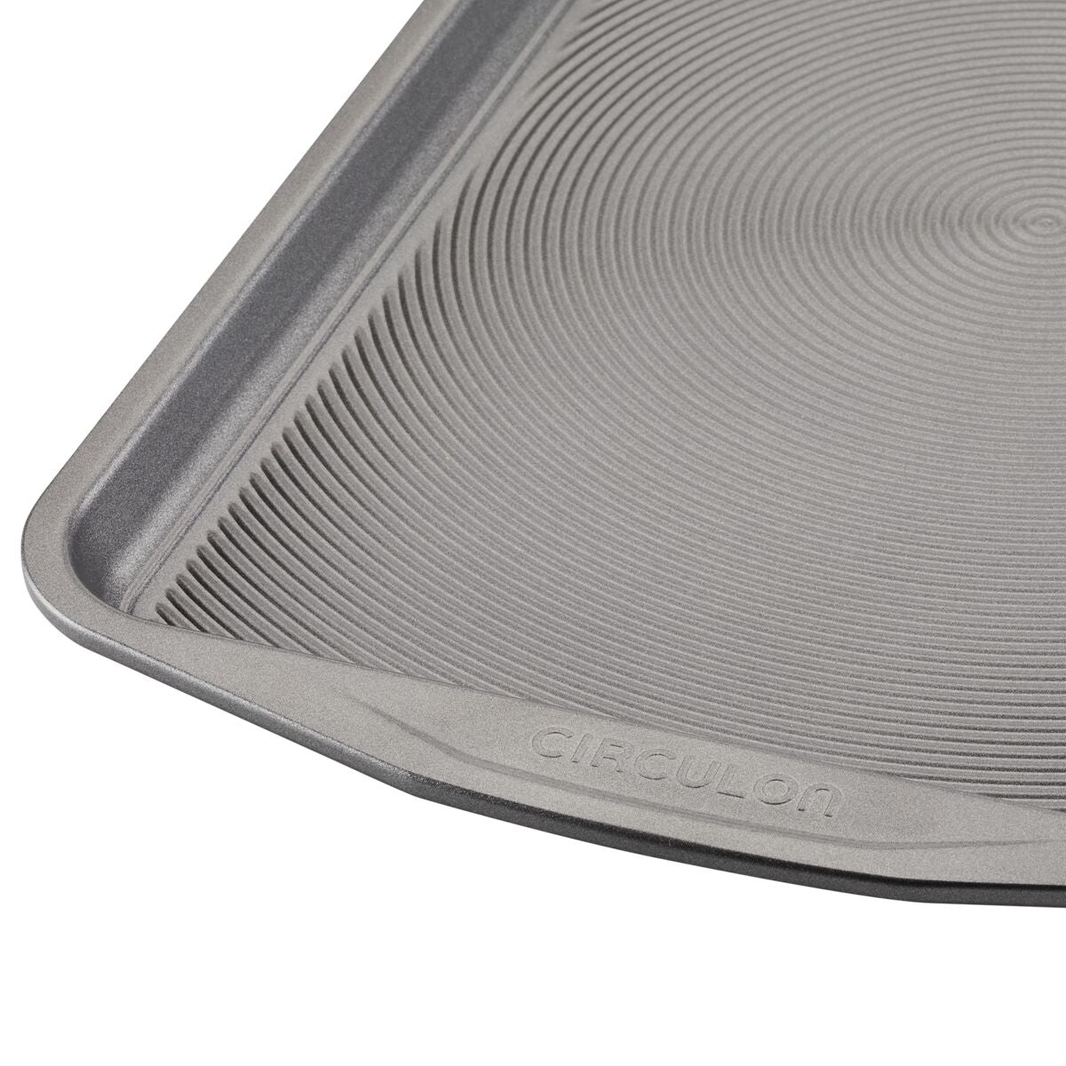 Close-up of a circular textured pan from the Nonstick Bakeware Set marked "Circulon," showcasing an advanced nonstick system for effortless baking.