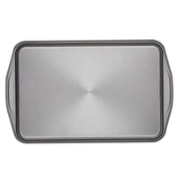 Nonstick Bakeware Set featuring a rectangular baking sheet with an advanced nonstick system, ridged pattern, and convenient handles for easy maneuvering.