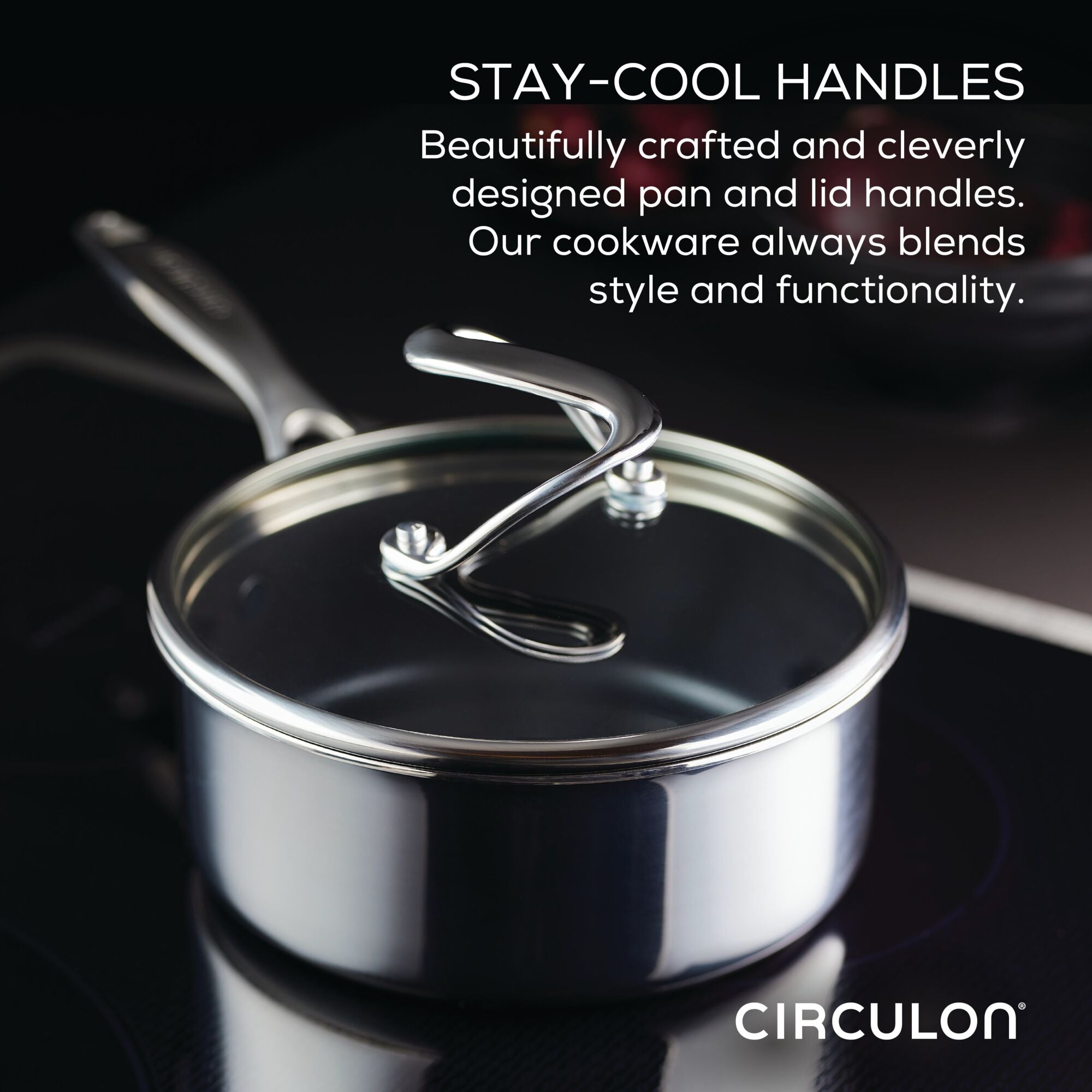 A stainless steel pot with stay-cool handles on a stovetop.