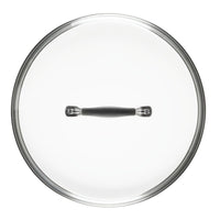 A round glass pot lid with a black handle, viewed from above.