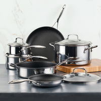 Stainless steel cookware set arranged on a dark surface.