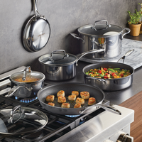 A variety of dishes cooking in stainless steel pots and pans on a stove.