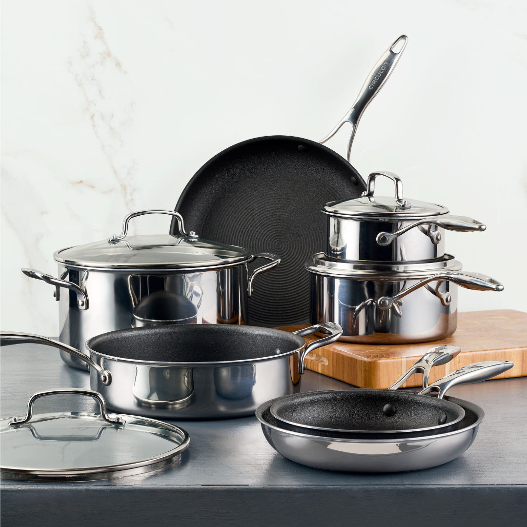 Stainless steel cookware set displayed on a kitchen countertop.