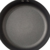 Empty non-stick frying pan with a circular pattern on the cooking surface.