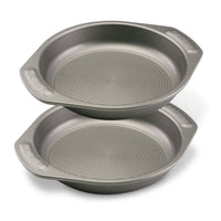 Two stacked round baking pans with handles and textured bottoms.