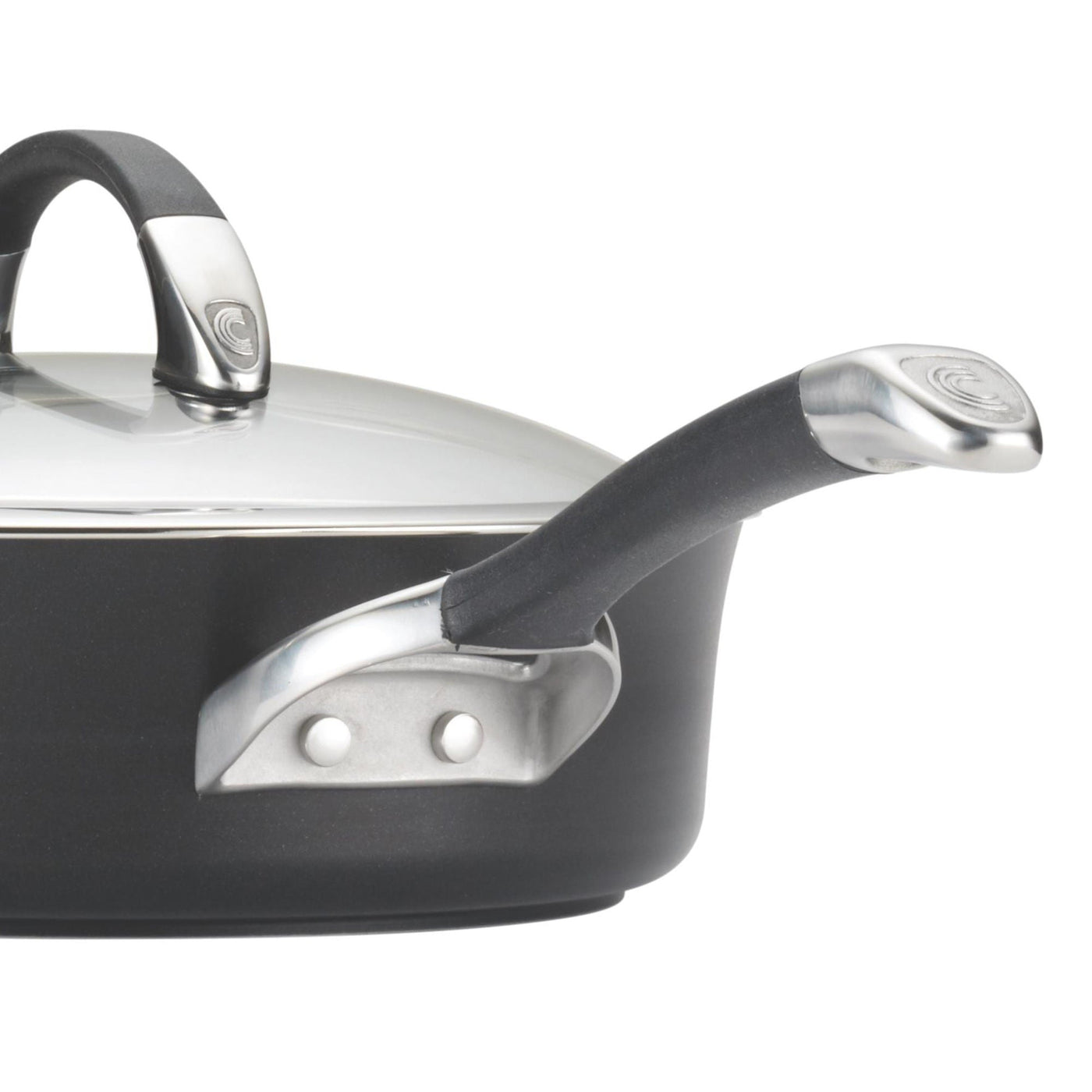 A close-up of a black saucepan with metal handles and a glass lid.