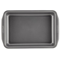 Viewed from above, the baking pan in the 5-Piece Nonstick Bakeware Set features a textured, nonstick surface for easy food release and is constructed from heavy-gauge steel to prevent warping, making it an essential addition to any kitchen.