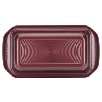 9" x 5" Nonstick Bakeware Loaf Pan crafted with premium quality, featuring a maroon finish and a circular pattern on the bottom.