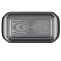 High-quality nonstick 9" x 5" loaf pan with an elegant embossed circular pattern, ideal for baking delicious treats.