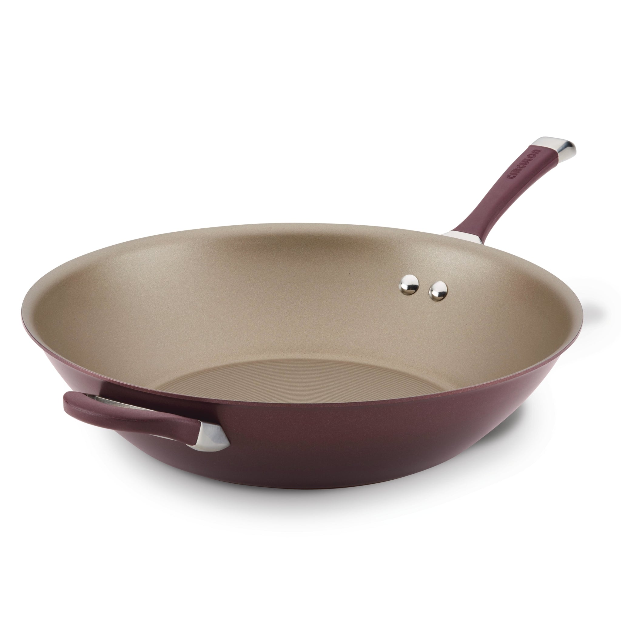 The 14-Inch Nonstick Stir Fry in purple is equipped with a handle and helper handle, featuring a durable non-stick coating achieved through the advanced TOTAL Nonstick System.