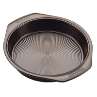 The 5-Piece Nonstick Bakeware Set includes a round baking pan made from heavy gauge steel, designed with raised concentric circles on the base to improve warp resistance.